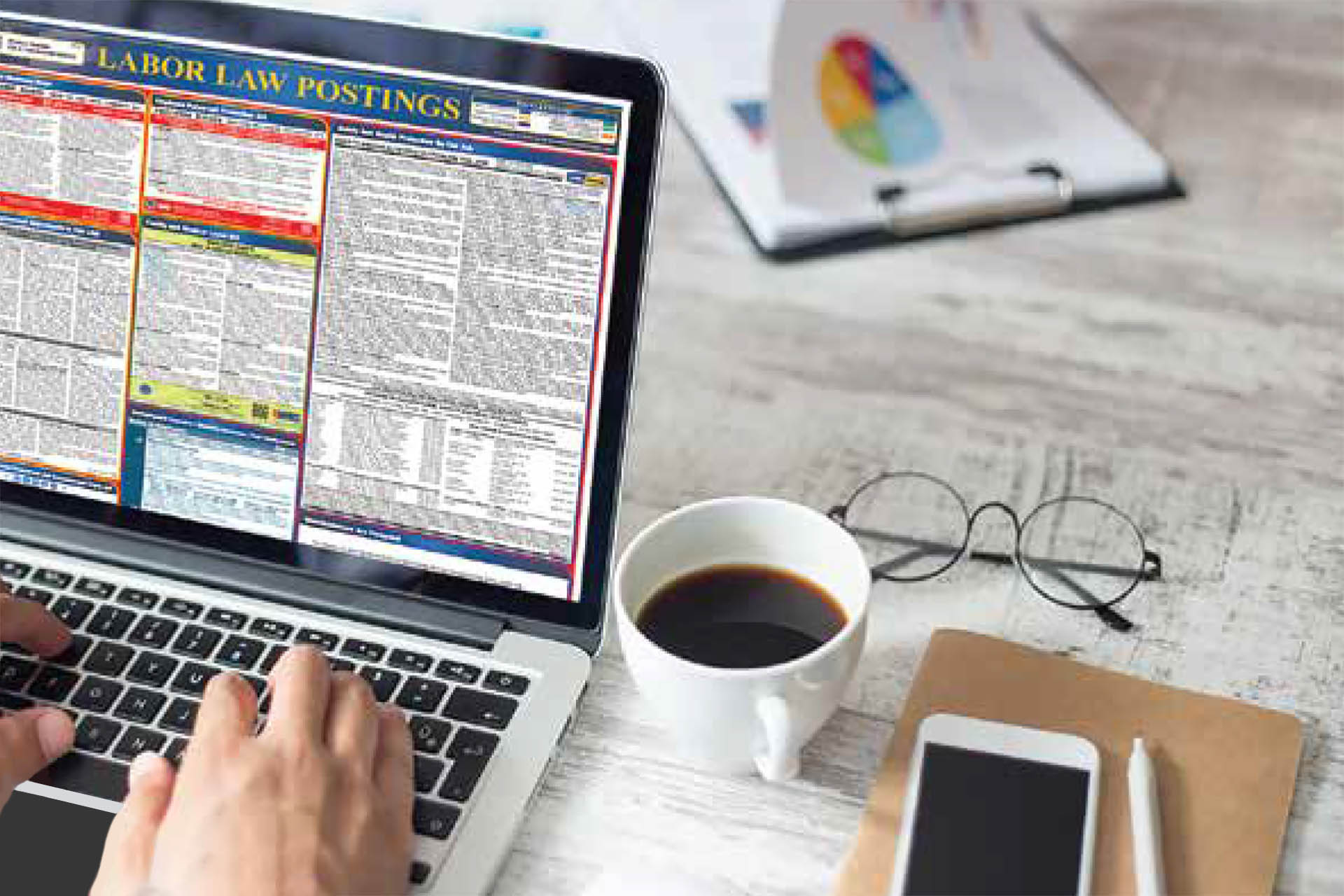 Labor Law – 2 Laptop with labor law poster, coffee, phone, glasses, and pen