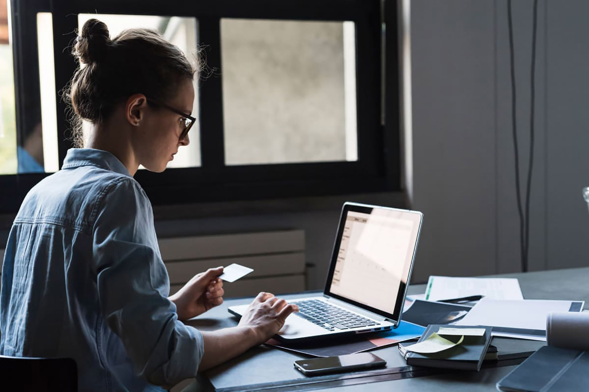 woman working holding a card on laptop